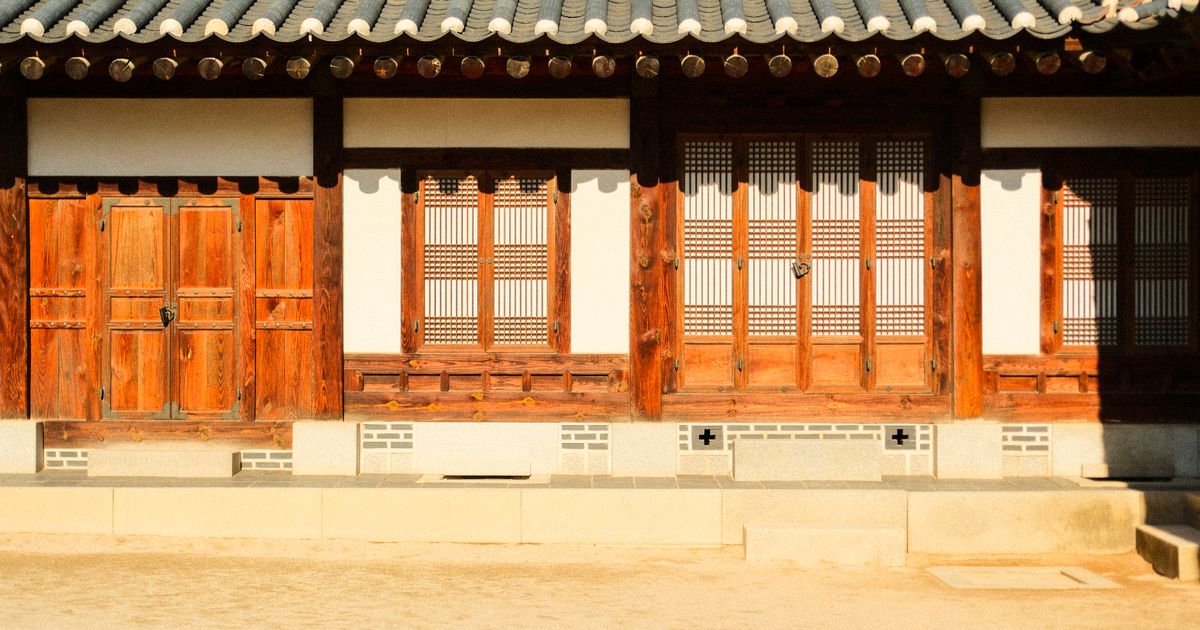 나무 대문과 창살 문이 나란히 있는 한옥 앞면