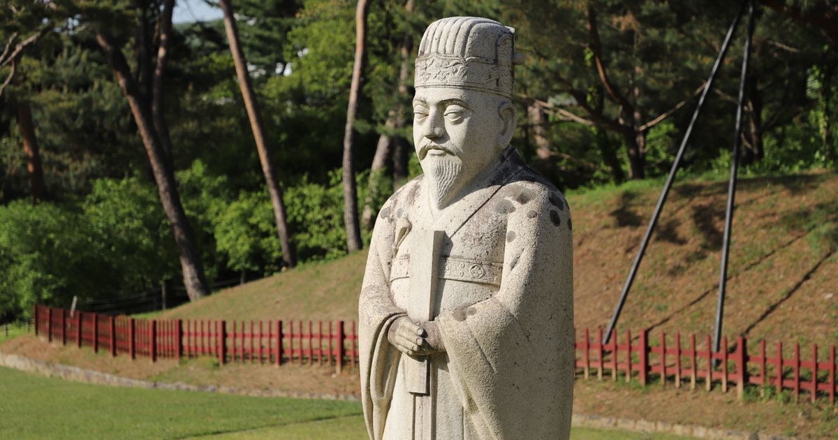 잔디 언덕과 소나무 숲을 뒤로하고 선 옛 돌 문인상