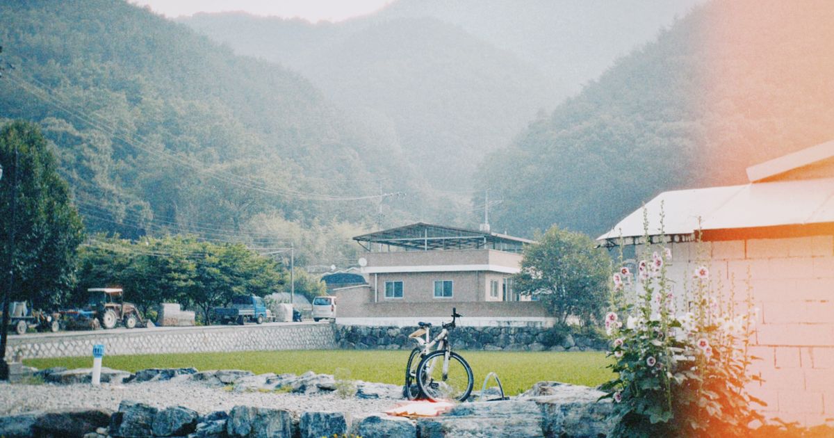 산줄기에 둘러싸인 골짜기 마을과 논 앞에 세워 둔 자전거